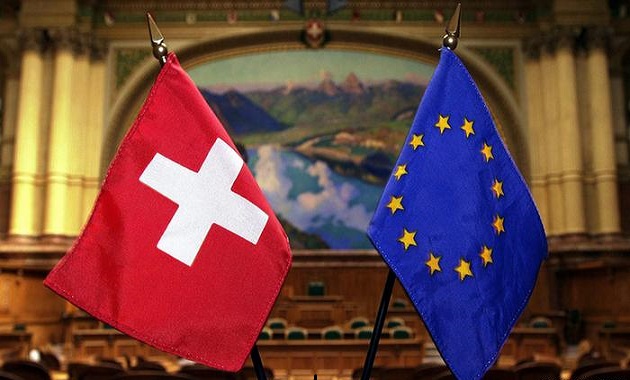 Swiss flag waving against a backdrop of the Swiss Alps